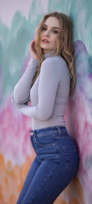 Blonde girl model standing aside wall phone wallpaper