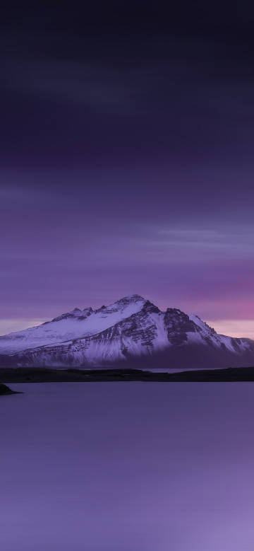 Snow-capped mountain scenery under purple glow phone wallpaper