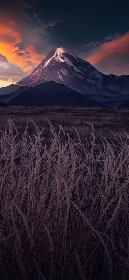 Stunning view of towering snow-capped mountains at sunset