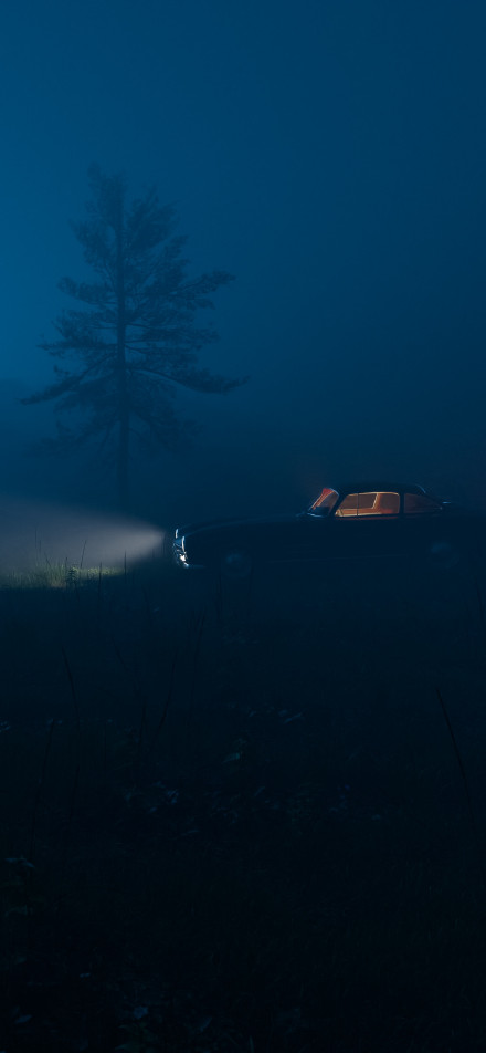 Car with lights on in the night fog phone wallpaper