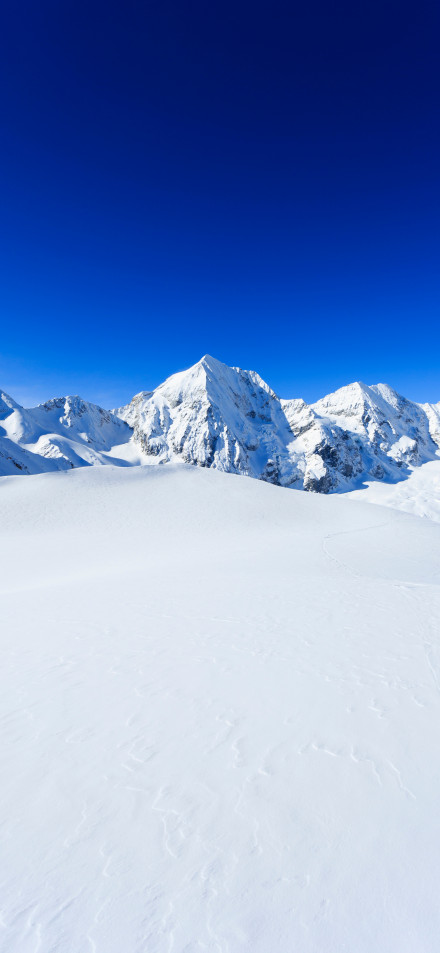 Majestic snow-capped mountains under clear winter sky phone wallpaper