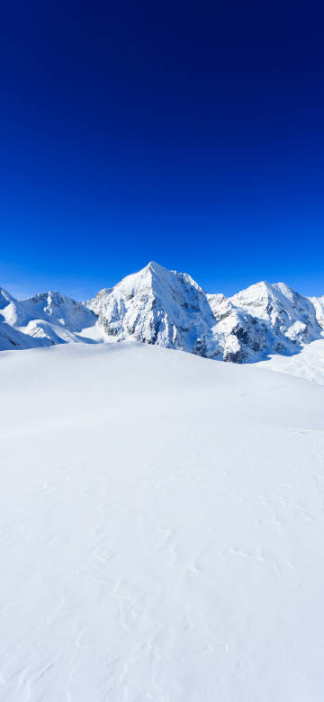 Majestic snow-capped mountains under clear winter sky phone wallpaper