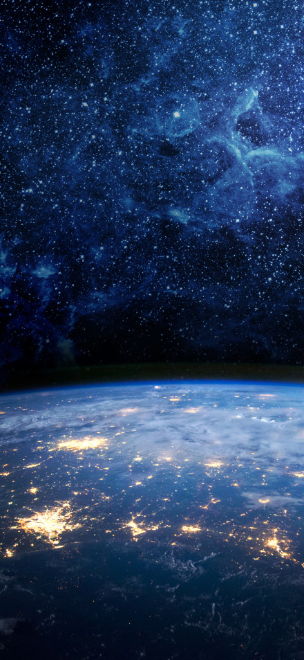 A brightly lit earth under a starry night sky