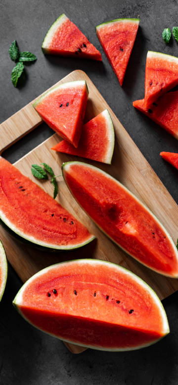 Freshly cut watermelon on wooden cutting board phone wallpaper