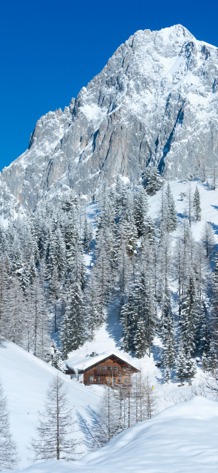 Wooden houses and snow-capped mountains in the Alps valley