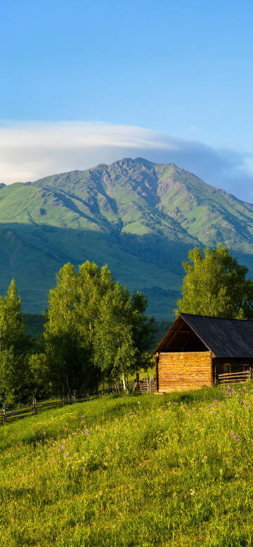 Hut on a hill under a clear blue sky phone wallpaper