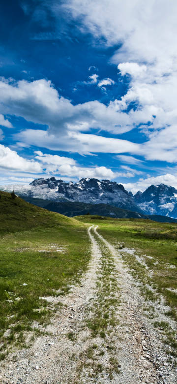 Alps mountains natural wallpaper: trail under blue sky and white clouds
