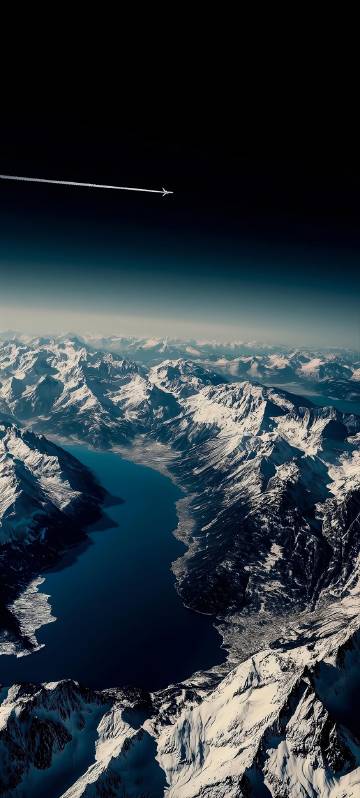 Snowy Mountains Under Dark Sky with Jet Contrail 4K Wallpaper