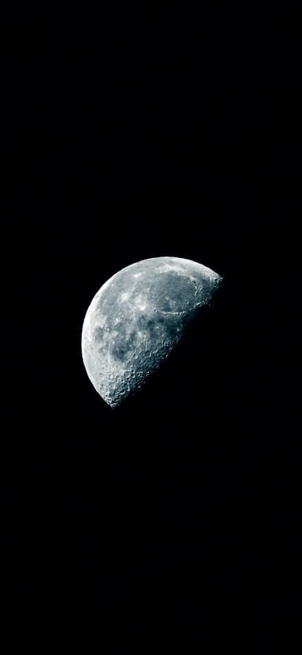 A half-moon in a deep black night sky phone wallpaper