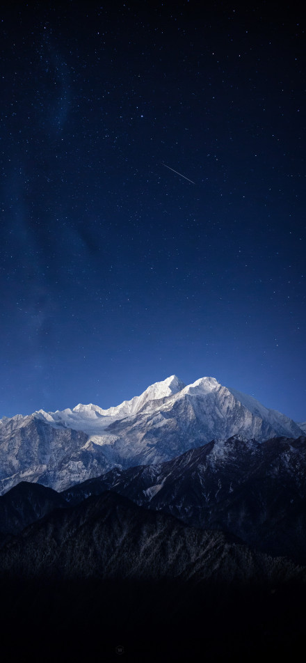 Breathtaking snow-capped mountains under a deep blue starry sky