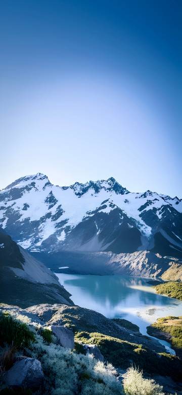 Snowy Mountains and a Glacial Lake Under a Blue Sky 4K Wallpaper