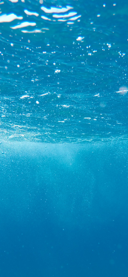 Underwater footage of clear blue water phone wallpaper