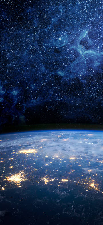 A brightly lit earth under a starry night sky