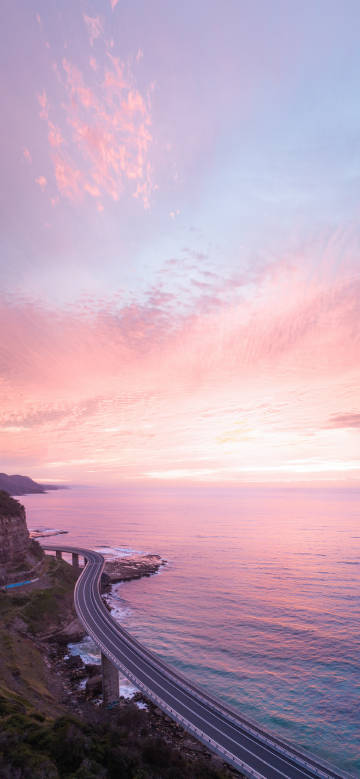Coastal highway in pink-purple afterglow phone wallpaper