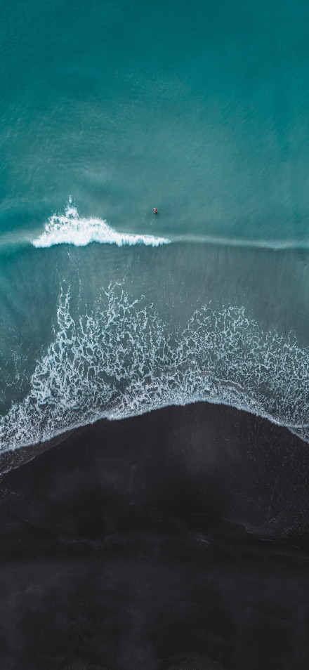 Aerial View of Turquoise Ocean Waves and Black Sand 5K Wallpaper