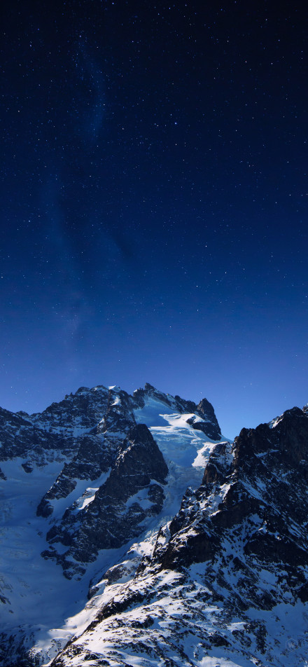 Beautiful snow-capped mountains under a deep blue starry sky