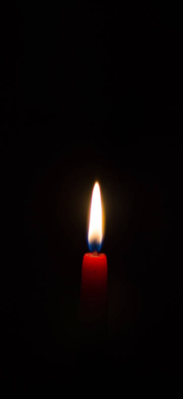 Burning red candles on black background
