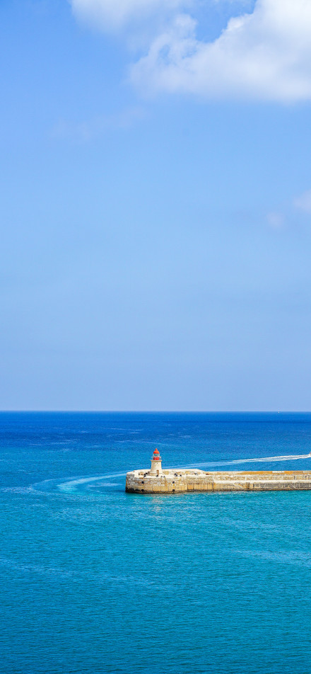 Quiet scene of lighthouse in blue sea phone wallpaper