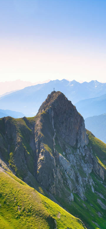 Alpine scenery with a cross at the top of the mountain