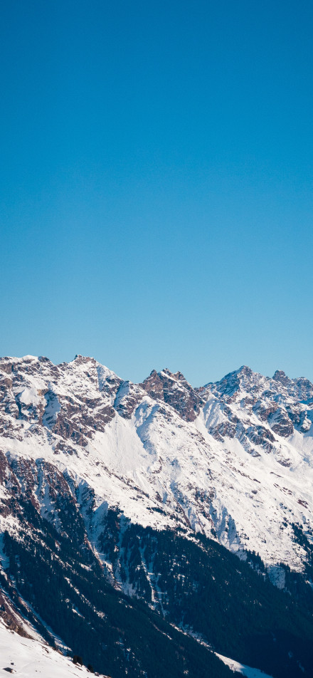 Snow-capped mountains under the pure blue sky phone wallpaper