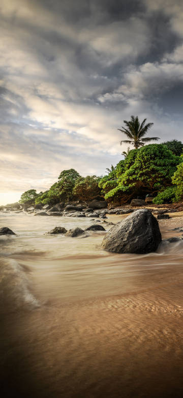 Seaside view of waves lapping at rocks phone wallpaper