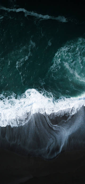 Stunning ocean overlook wallpaper: white waves on a black sand beach