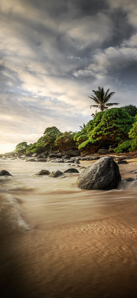 Seaside view of waves lapping at rocks phone wallpaper