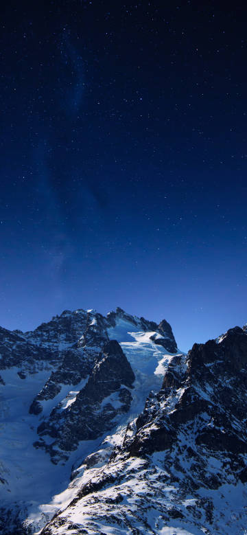 Beautiful snow-capped mountains under a deep blue starry sky