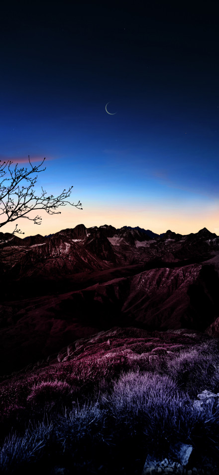 Quiet scene of mountains and crescent moon at night
