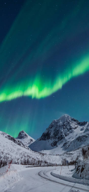 Dreamy scene of aurora over snowy road phone wallpaper