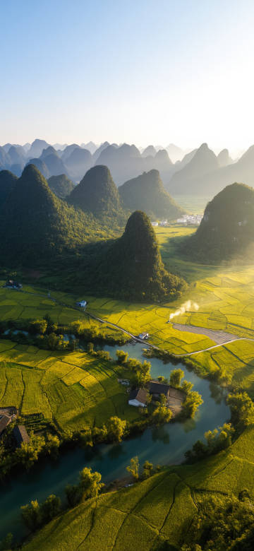 A rural village surrounded by peaks and forests phone wallpaper