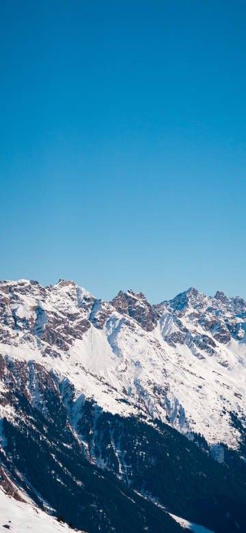 Snow-capped mountains under the pure blue sky phone wallpaper