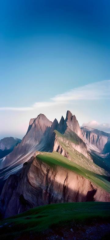 Green Hillside Under Jagged Mountain Peaks 4K Wallpaper