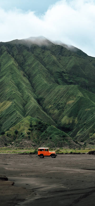 Orange off-road vehicle under Mount Bromo phone wallpaper