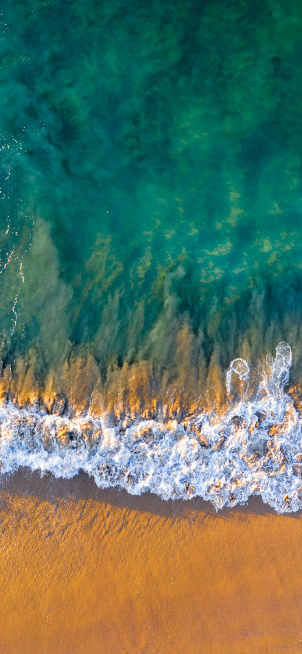 Waves crashing onto the beach phone wallpaper
