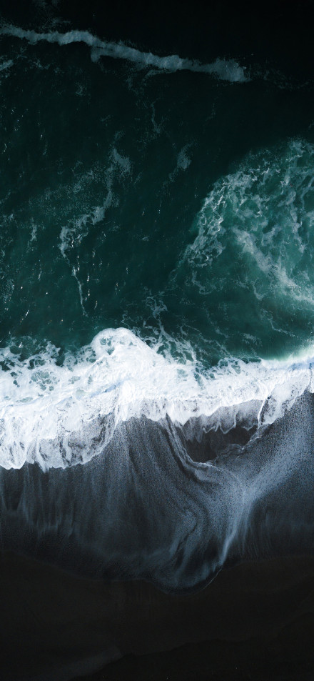 Stunning ocean overlook wallpaper: white waves on a black sand beach