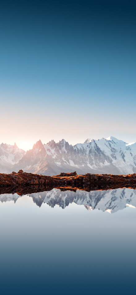 Snow-covered mountains in the morning light phone wallpaper