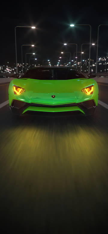 Green Lamborghini sports car speeding on the city road at night