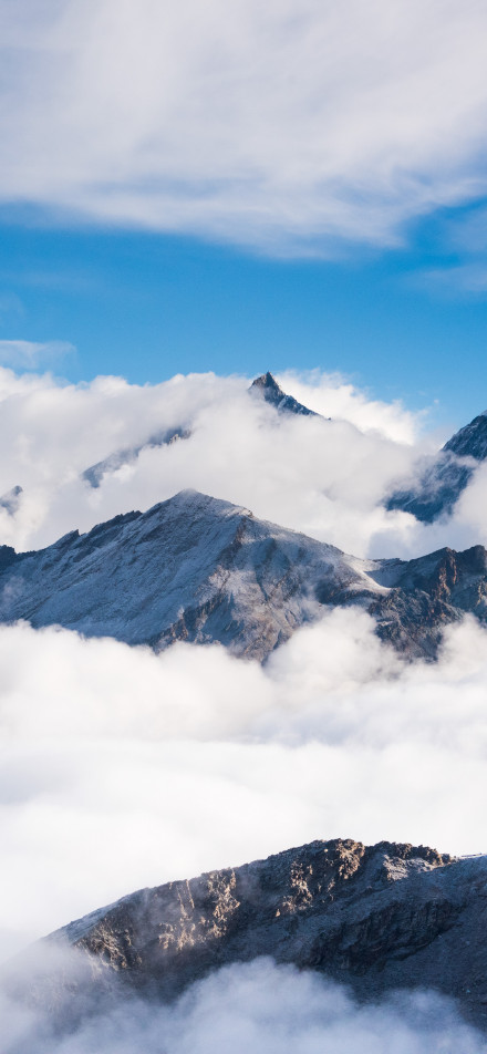 Magnificent scenery of mountains surrounded by white clouds under the blue sky