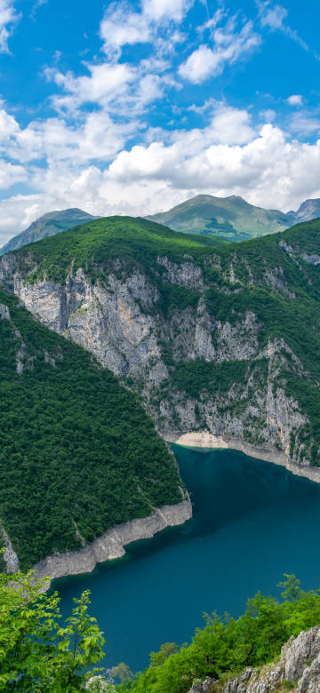 Beautiful view of Lake Piva under blue sky and white clouds