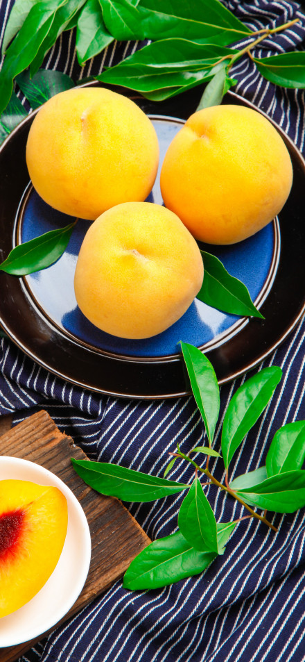 Fresh Yellow Peaches on a Blue Plate