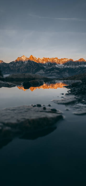 Golden Snowy Mountains Reflecting In A Puddle 8K Wallpaper