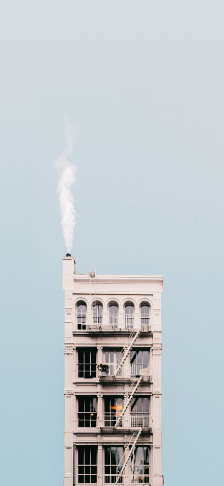 Building with smoke on roof phone wallpaper