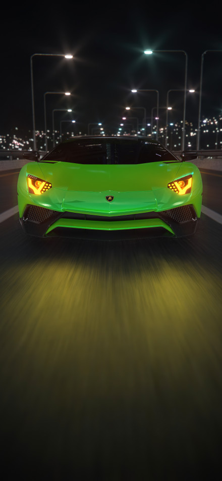 Green Lamborghini sports car speeding on the city road at night