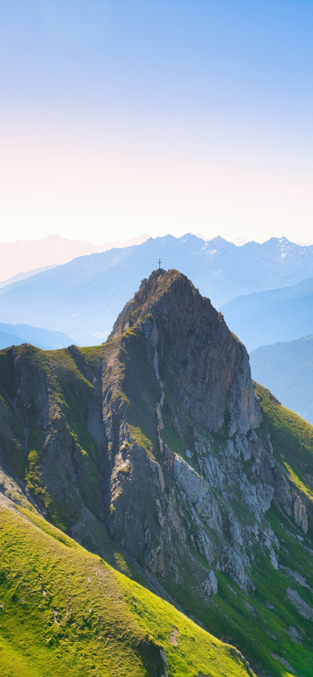 Alpine scenery with a cross at the top of the mountain