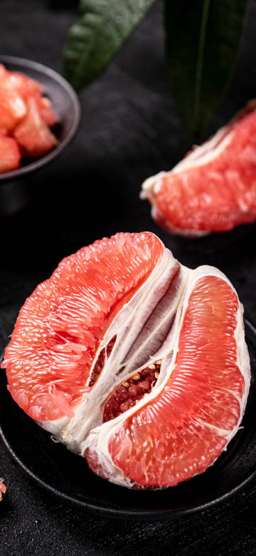 Sliced Ruby Pomelo on Black Plate 4K Phone Wallpaper