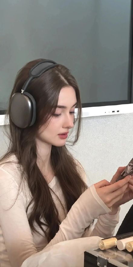 Girl wearing headphones playing with mobile phone