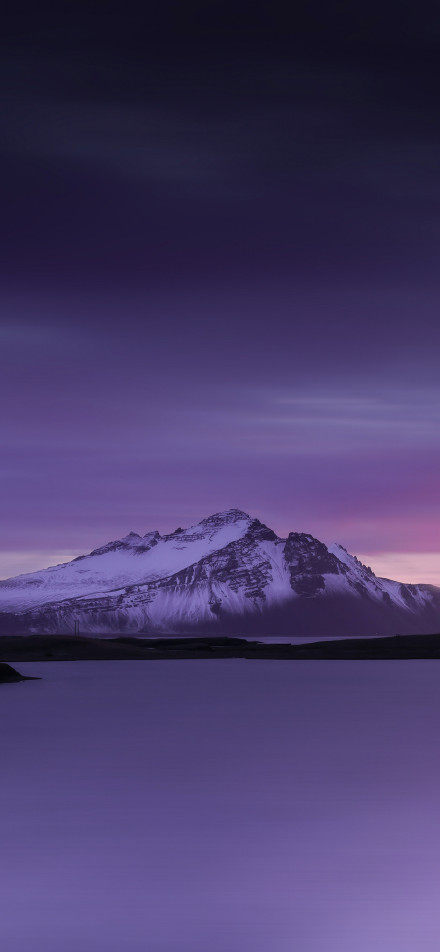 Snow-capped mountain scenery under purple glow phone wallpaper