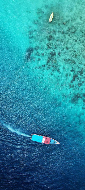 Aerial view of boats sailing on gradient blue water phone wallpaper
